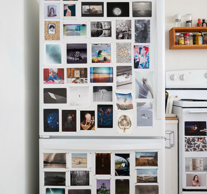 photo of a fridge with photos all over it.