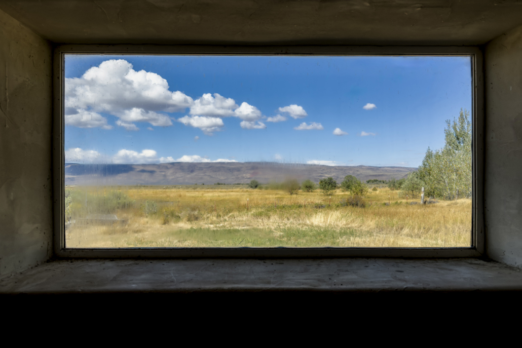 view through a slightly dirty window onto a desert grassland landscape